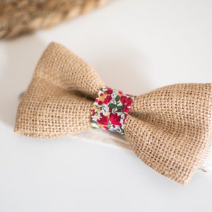 Peut inclure: Un nœud papillon en toile de jute marron avec une bande à motif floral rouge et blanc.