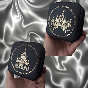 May include: Black square jewelry box with a gold castle design and the text "HERE YOU LEAVE TODAY AND ENTER THE WORLD OF YESTERDAY, TOMORROW, AND FANTASY". The box has a textured surface and a zipper closure.
