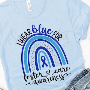 May include: A light blue t-shirt with a rainbow design and the text "I WEAR blue FOR foster & care awareness".