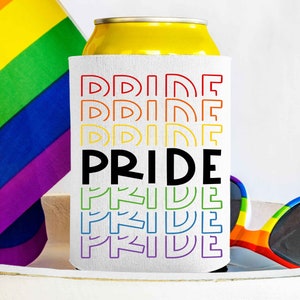 Könnte beinhalten: Weißer Getränkedosenkühler mit Regenbogenmuster und dem Wort "PRIDE" in schwarzen Buchstaben. Der Kühler steht auf einer weißen Oberfläche mit einer regenbogenfarbenen Sonnenbrille.