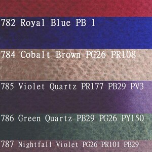 May include: A close-up of a color chart showing different shades of blue, green, red, brown, violet, and yellow. The chart is labeled with numbers and paint pigment codes, such as "779 Prussian Blue PB 27", "780 Royal Green PB 15:3 PR 101", and "781 Burgundy Red PR 177".
