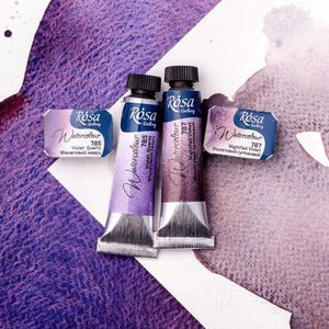 May include: Two tubes of Rosa Gallery watercolor paint. The tubes are labeled "Violet Quartz 785" and "Nightfall Violet 787".