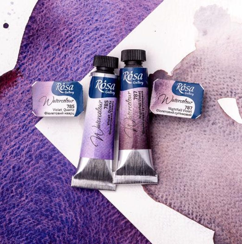 May include: Two tubes of Rosa Gallery watercolor paint. The tubes are labeled "Violet Quartz 785" and "Nightfall Violet 787".