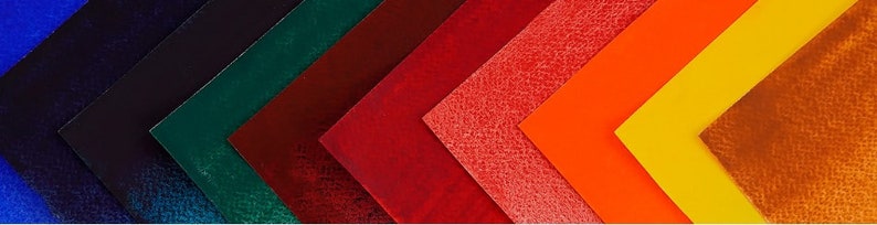 May include: A collection of ten fabric swatches in various colours, including blue, green, red, orange, and brown. The swatches are arranged in a diagonal pattern, with the darkest colours at the top and the lightest colours at the bottom.