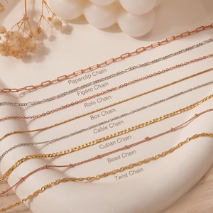 May include: A close-up of ten different types of gold chains, including paperclip, figaro, rolo, box, cable, cuban, bead, and twist chains. Each chain is labeled with its name.