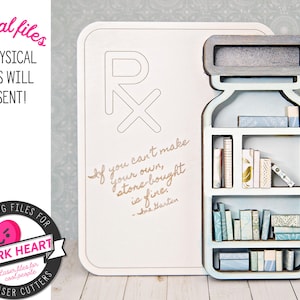 May include: A white wooden sign with a blue and white bookshelf shaped like a bottle. The sign has a large "Rx" symbol and the text "If you can't make your own, store bought is fine. -Ana Barten".