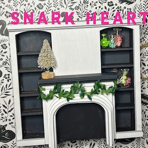 May include: A white painted miniature fireplace with a black mantel and shelves. The shelves are decorated with small glass jars filled with candy. A small artificial Christmas tree sits on the mantel.