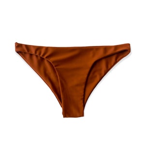 Può includere: Un fondo bikini marrone con un design semplice e classico.