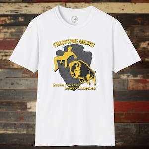 May include: White t-shirt with a yellow graphic of a person running from a buffalo with the text "Yellowstone Airlines" and "Rough Takeoffs Bumpy Landings".