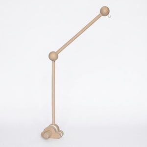 May include: A light-colored wooden mobile arm featuring a cloud-shaped base, a vertical rod, a central spherical joint, and an angled upper rod ending in a spherical tip with a small white hook for hanging items from the mobile structure.