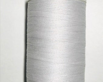 May include: A spool of light gray thread with the text "1,547 yds/vgs" and "CA 0277" printed on the label.