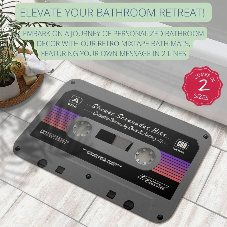 K&ouml;nnte beinhalten: Eine graue Badematte in Form einer Kassette mit dem Text "Shower Serenades Hits" und "Cassette Classics by Ohia & Antony". Die Matte hat ein rot-violettes Design und den Text "C60 Low Noise" und "Compact Cassette".