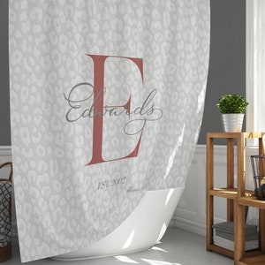 May include: A white shower curtain with a gray leopard print pattern. The letter "E" is in a red color with the name "Edwards" written in cursive script below it. The text "Est. 2002" is printed below the name.