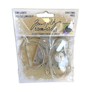 May include: A packet of tiny Christmas lights. The package contains two light strands with multicoloured lights. The package has the text "Tiny Lights" and "Christmas" printed on it. The brand name "idea-ology" is also printed on the package.