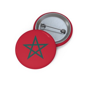 May include: A red button with a green five-pointed star in the center. The button is a promotional item with a metal back.