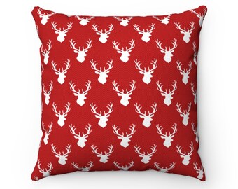 May include: Red throw pillow with a white deer silhouette pattern.