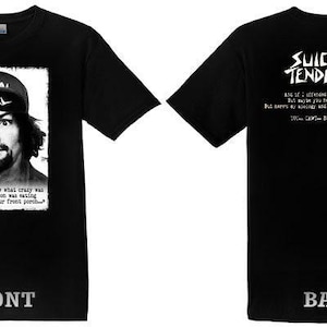 Könnte beinhalten: Schwarzes T-Shirt mit einem Schwarz-Weiß-Bild eines Mannes mit einem Hut mit dem Wort "SUICIDAL". Auf der Vorderseite des T-Shirts befindet sich ein Zitat unter dem Bild. Auf der Rückseite des T-Shirts stehen die Worte "SUICIDAL TENDENCIES" und ein Zitat.