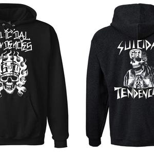 Könnte beinhalten: Schwarzer Hoodie mit weißen Grafikdesigns. Die Vorderseite zeigt den Text "SUICIDAL TENDENCIES" über einem Totenkopf mit Flammen und den Buchstaben "SXT". Die Rückseite zeigt einen Totenkopf mit "SUICIDAL TENDENCIES" und den Buchstaben "ST".