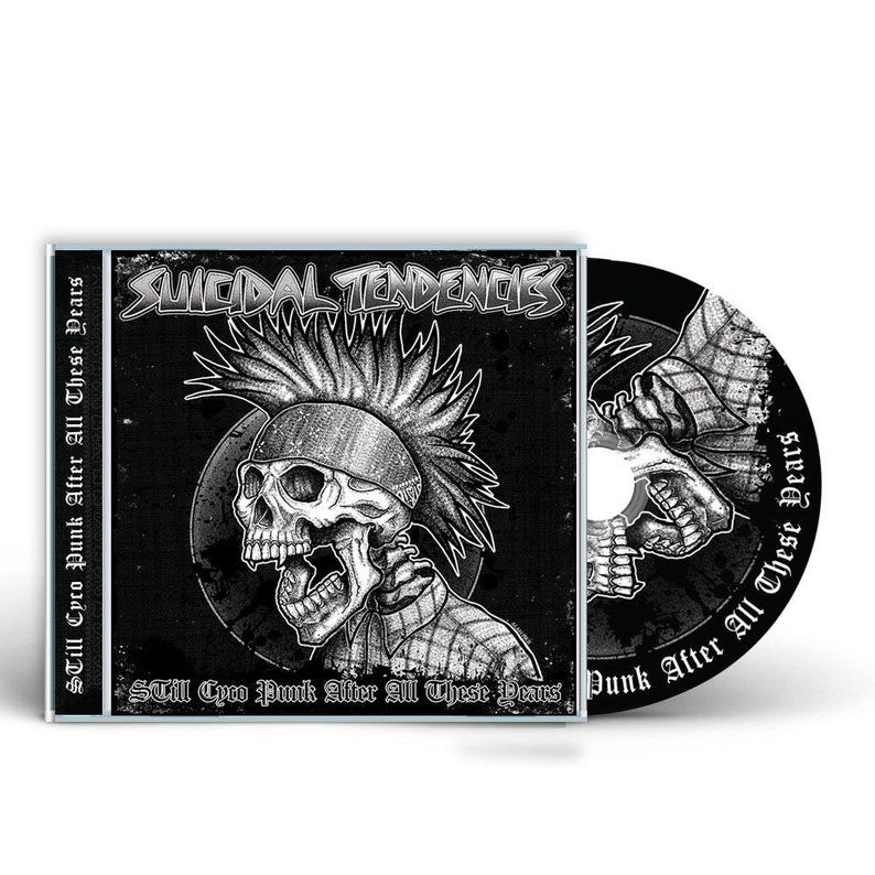 May include: A CD case and disc with a monochrome illustration of a skull sporting a mohawk. The words "SUICIDAL TENDENCIES" are displayed. The text "STILL CYCO PUNK AFTER ALL THESE YEARS" is also visible.