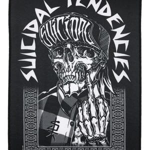 Könnte beinhalten: Schwarz-weißer Aufnäher mit einem Schädel, der eine Mütze trägt und den Mittelfinger zeigt. Die Worte "SUICIDAL TENDENCIES" sind um den Schädel herum angeordnet. Der Schädel trägt ein kariertes Hemd. Eine dekorative Bordüre umgibt das Bild.