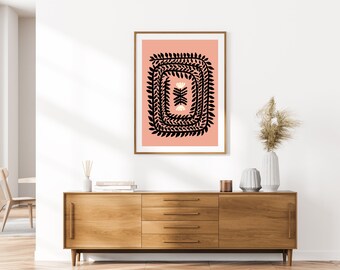 Könnte beinhalten: Ein gerahmter Druck mit rosa Hintergrund und einem schwarzen floralen Design. Das Design zeigt einen quadratischen Rahmen aus sich wiederholenden schwarzen Blättern mit einem weißen floralen Muster in der Mitte.