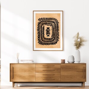 May include: A black and white abstract print of a stylized plant with a square frame on a beige background.