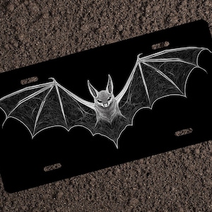 May include: A black and white graphic of a bat with its wings spread wide. The bat is outlined in white and has a detailed, web-like pattern on its wings.