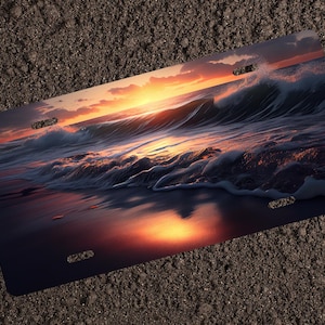 May include: A sunset over the ocean with a wave crashing on the shore. The sky is a mix of orange, pink, and purple, and the water is a deep blue. The sand is a light brown.