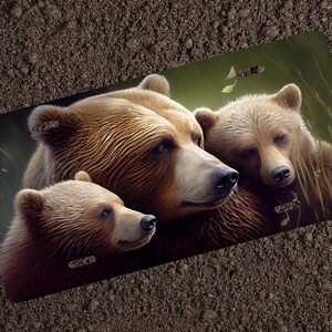 May include: A close-up of three brown bears. The mother bear is in the center, with her two cubs on either side. The bears are looking at the camera with gentle expressions. The background is a soft green with blurred foliage.