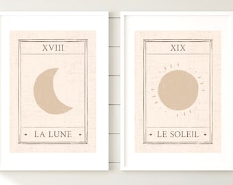 Peut inclure: Deux impressions encadrées avec un fond beige et des contours noirs. L'impression de gauche présente un croissant de lune avec le texte "XVIII LA LUNE". L'impression de droite présente un soleil avec le texte "XIX LE SOLEIL".