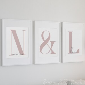 May include: Three framed prints with the letters N, & and L in a dusty rose color. The names Naomi and Liam are written in cursive below the letters.