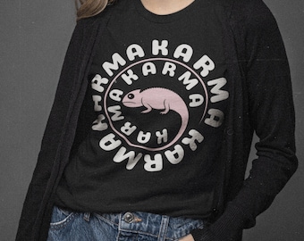 Könnte beinhalten: Ein schwarzes T-Shirt mit einer weißen Grafik eines rosa Chamäleons in einem Kreis mit dem Text "Karma Karma Karma", der sich um den Kreis herum wiederholt.