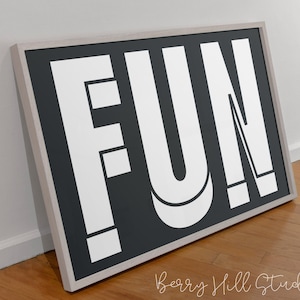 May include: A framed black and white print with the word "FUN" in bold white letters on a black background.