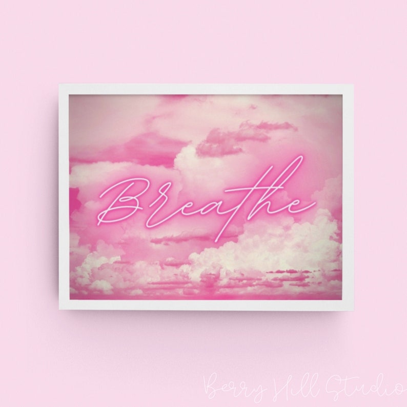 May include: A pink and white digital art print with the word "Breathe" in neon pink lettering. The background is a pink and white cloudy sky.