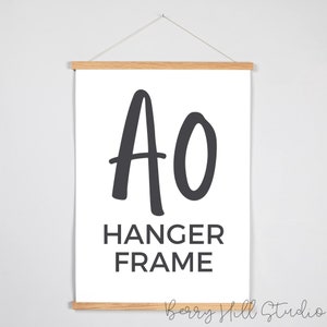 Op de afbeelding: Een witte canvas print met een zwart-witte afbeelding van de letters "AO" en de tekst "HANGER FRAME".