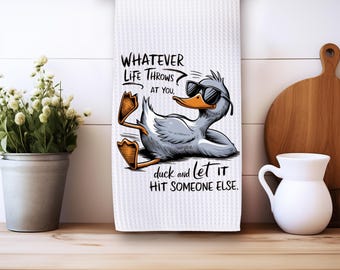 May include: White kitchen towel with a cartoon duck wearing sunglasses and the text "Whatever life throws at you, duck and let it hit someone else."