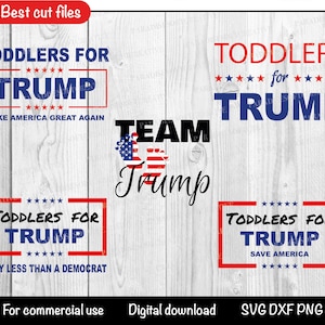Puede incluir: Cuatro letreros rectangulares rojos y blancos con el texto "Toddlers for Trump" y varios lemas. Los letreros están sobre un fondo de madera blanca con un corazón rojo, blanco y azul con el texto "Team Trump" en negro.