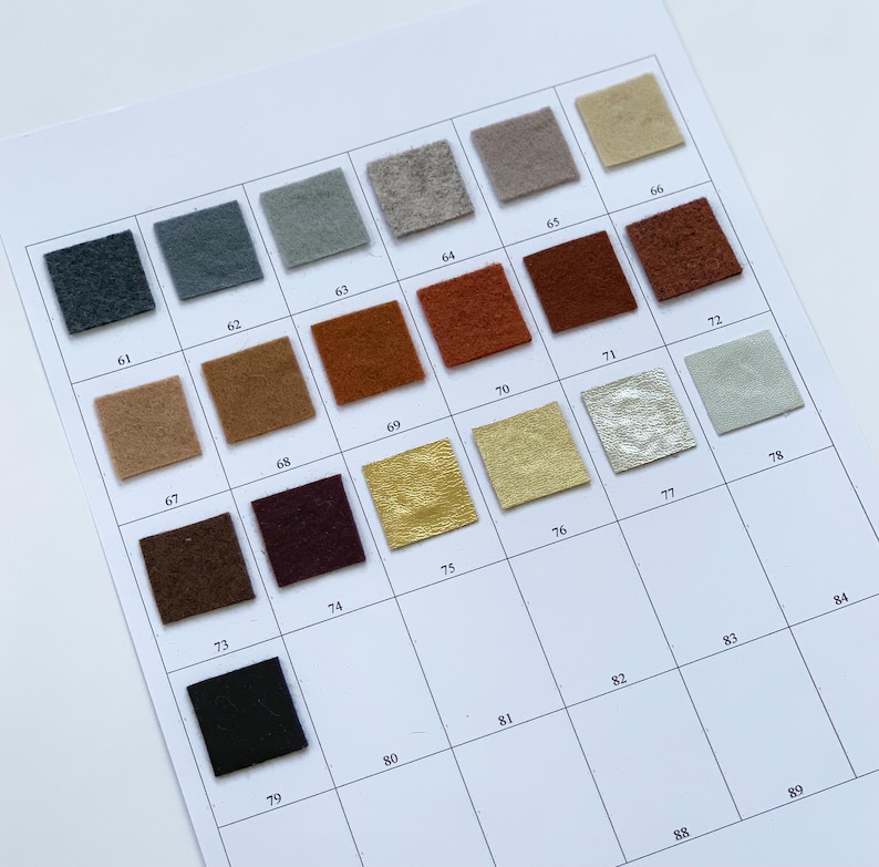 May include: A color chart featuring small, square fabric swatches in various colors, including shades of blue, brown, gold, and green. Each swatch is numbered, with a white background.