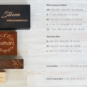 May include: Wooden boxes in various sizes and shapes, including rectangular, square, cigar, and cufflinks boxes. The rectangular box is black with "Steven GROOMSMAN" engraved. The square box is brown with "Nathan GROOMSMAN" engraved. Sizes are listed in inches and centimeters.