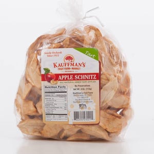 May include: A bag of dried apple slices, labeled "KAUFFMAN'S FRUIT FARM & MARKET APPLE SCHNITZ ALL NATURAL DRIED TART APPLES". The bag is clear plastic and the apple slices are a light brown color. The bag is tied with a twist tie. The label also includes the nutrition facts and the company's contact information.