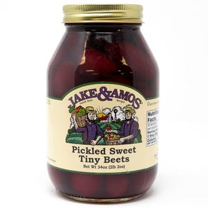 May include: A clear glass jar filled with dark red pickled sweet tiny beets, topped with a gold metal lid. The cream-colored label features the text Jake & Amos, Pickled Sweet Tiny Beets, and a net weight of 34oz (2lb 2oz) with illustrations.