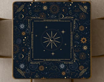 May include: A square dark blue game mat featuring gold celestial motifs including suns, moons, and stars. The centre displays a large star, surrounded by text borders reading "Charleston," "Walls Left," "Play Right," and "No Jokers in Single Pairs."