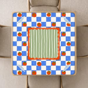 May include: Square table with a blue and white checkered pattern, orange tomatoes, and green and white striped center. The table has a wooden frame and is surrounded by four beige chairs. Text on the table reads "BALLS LEFT" and "PLAY RIGHT".