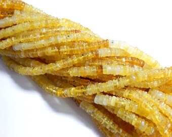 May include: A strand of yellow opal beads, each bead is a small, rounded rectangle.