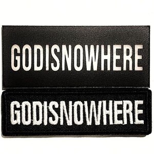 May include: Two black fabric patches with white embroidered text that reads "GOD IS NOWHERE".