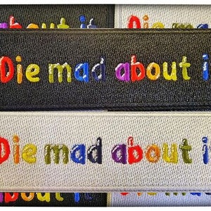 May include: Two embroidered patches with the text "Die mad about it" in rainbow colors. The top patch is black and the bottom patch is white.