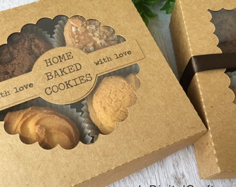 May include: A brown cardboard box with a clear window showing homemade cookies. The box has a label that says "Home Baked Cookies" with a heart and the words "with love".