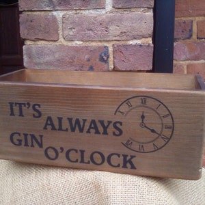 May include: A wooden box with the text "It's Always Gin O'Clock" and a clock face printed on it.