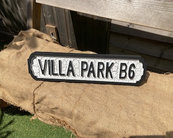 May include: Black and white street sign with the text "VILLA PARK B6" on a white background with a black border.