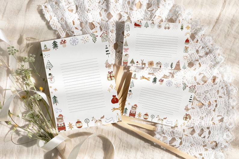 May include: Three white sheets of paper with a Christmas theme border. The border features illustrations of a snowman, a house, a Christmas tree, a reindeer, a gift, a stocking, and other winter holiday symbols. The paper is lined for writing.